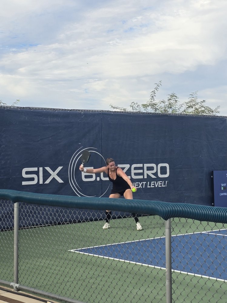 Cailyn Campbell hitting a forehand at the Veolia Arizona Open in front of the Six Zero Pickleball banner